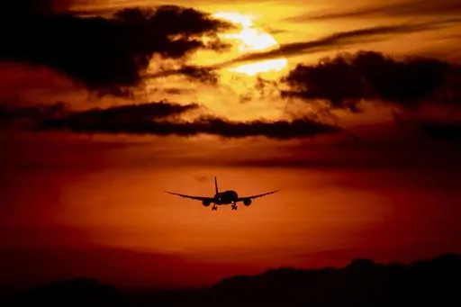 An aircraft approaches the airport in Frankfurt, Germany, as the sun rises on Thursday, Aug. 27, 2020. Mystery travel involves setting off on a trip where you only know the destination once you board the plane. These trips are popular among friend and family groups, and travel booking companies have begun offering mystery travel packages. (AP Photo/Michael Probst, File)