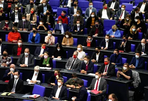 CORRECTS DATE -- Lawmakers wear face mask as they attend a parliament Bundestag session about new measures to battle the coronavirus pandemic at the Reichstag building in Berlin, Germany, Thursday, Nov. 18, 2021. (AP Photo/Markus Schreiber)