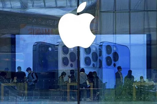 People shop at an Apple Store in Beijing, Tuesday, Sept. 28, 2021. Apple disclosed serious security vulnerabilities Wednesday, Aug. 17, 2022 for iPhones, iPads and Macs. The software flaws could potentially allow attackers to take complete control of these devices, Apple said.  (AP Photo/Andy Wong, File)