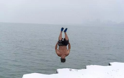 "The Great Lake Jumper" Dan O'Conor takes a plunge into the frigid waters of Lake Michigan, as he does every morning, Thursday, Jan. 26, 2023, in Chicago. O'Conor has jumped every day since June 2020. Celebrities and regular folk are plunging into frigid water for their social media feeds, but the science on the supposed benefits is lukewarm.(AP Photo/Erin Hooley)