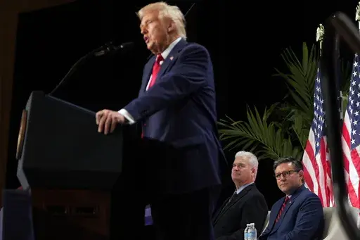 Rep. Tom Emmer, R-Minn., and House Speaker Mike Johnson of La., listen as President Donald Trump speaks at the 2025 House Republican Members Conference dinner at Trump National Doral Miami in Doral, Fla., Monday, Jan. 27, 2025. (AP Photo/Mark Schiefelbein)