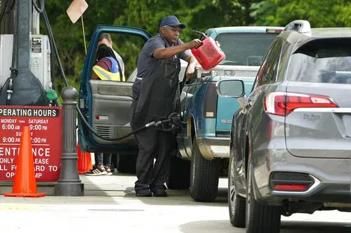 A customer pumps gas at this Madison, Miss., Sam's Club, after filling up a gasoline container, Tuesday, May 24, 2022. Wholesale retail chains stores like Costco and Sam's Club tend to price their gas and diesel competitively against one another while major gas chain prices are usually higher. (AP Photo/Rogelio V. Solis)