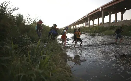 Venezuelan migrants walk across the Rio Bravo towards the United States border to surrender to the border patrol, from Ciudad Juarez, Mexico, Oct. 13, 2022. A surge in migration from Venezuela, Cuba and Nicaragua in September brought the number of illegal crossings to the highest level ever recorded in a fiscal year, according to U.S. Customs and Border Protection. (AP Photo/Christian Chavez, File)