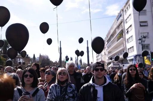 People obverse a minute of silence, during a protest outside the Greek parliament, in Athens, Greece, Sunday, March 5, 2023. Thousands protesters, take part in rallies around the country for fifth day, protesting the conditions that led the deaths of dozens of people late Tuesday, in Greece's worst recorded rail accident. (AP Photo/Aggelos Barai)