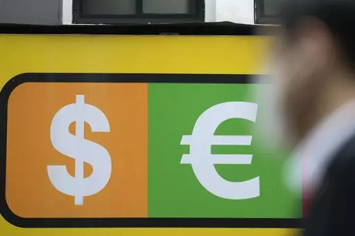 A man walks near a sign of foreign currency outside a money exchange office at a shopping district in Seoul, South Korea, Thursday, April 6, 2023. Asian shares were trading mostly lower Thursday as investors turned their attention to upcoming earnings reports and other economic indicators.(AP Photo/Lee Jin-man)
