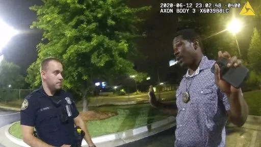 This screen grab taken from body camera video provided by the Atlanta Police Department shows Rayshard Brooks, right, as he speaks with Officer Garrett Rolfe, left, in the parking lot of a Wendy's restaurant in Atlanta, June 12, 2020. A specially appointed prosecutor said Tuesday, Aug. 23, 2022, that he will not pursue any charges against the Atlanta police officer who fatally shot Brooks more than two years ago. (Atlanta Police Department via AP, File)