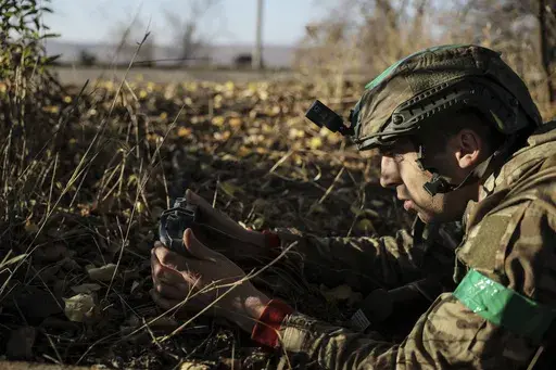 In this photo provided by Ukraine's 24th Mechanised Brigade press service, a serviceman of the 24th Mechanised Brigade installs landmines and non explosive obstacles along the front line near Chasiv Yar town in Donetsk region, Ukraine, Wednesday Oct. 30, 2024. (Oleg Petrasiuk/Ukrainian 24th Mechanised Brigade via AP)