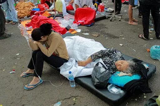 Earthquake survivors are treated outside of a hospital in Cianjur, West Java, Indonesia, Monday, Nov. 21, 2022. An earthquake shook Indonesia's main island of Java on Monday damaging dozens of buildings and sending residents into the capital's streets for safety. (AP Photo/Kholid)