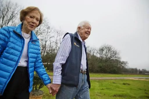 In this Feb. 8, 2017, photo, former President Jimmy Carter, right, and his wife Rosalynn arrive for a ribbon cutting ceremony for a solar panel project on farmland he owns in their hometown of Plains, Ga. Jimmy and Rosalynn are celebrating their 77th wedding anniversary, Friday, July 7, 2023. (AP Photo/David Goldman, File)