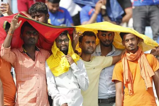 Cricket fans cover their heads with a long scarf to shield themselves from heat during an Indian Premier League (IPL) cricket match in Lucknow, India, April 22, 2023. A searing heat wave in parts of southern Asia in April this year was made at least 30 times more likely by climate change, according to a rapid study by international scientists released Wednesday, May 17. (AP Photo/Surjeet Yadav, File)