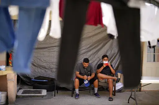 Two men from Nicaragua wait to apply for asylum in the United States Thursday, June 30, 2022, at a shelter for migrants in Tijuana, Mexico. The Supreme Court has ruled that the Biden administration properly ended a Trump-era policy forcing some U.S. asylum-seekers to wait in Mexico. (AP Photo/Gregory Bull)