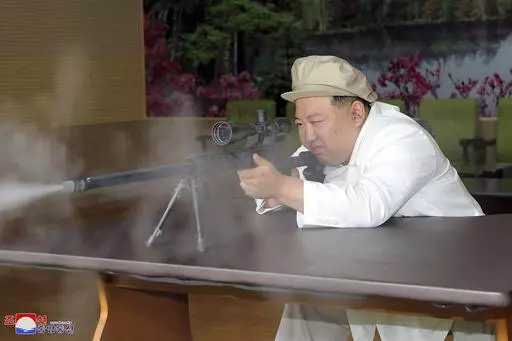 In this undated photo provided by the North Korean government, North Korean leader Kim Jong Un tries a weapon during his three-day inspection from Aug. 3 until Aug. 5, 2023 at major munitions factories in North Korea. Independent journalists were not given access to cover the event depicted in this image distributed by the North Korean government. The content of this image is as provided and cannot be independently verified. Korean language watermark on image as provided by source reads: "KCNA" 
