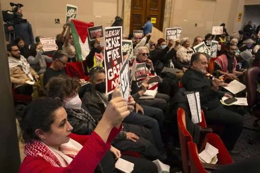 Audience members show their support at a special session of the Oakland City Council for a resolution calling for an immediate cease-fire in Gaza, Monday, Nov. 27, 2023, in Oakland, Calif. (AP Photo/D. Ross Cameron)