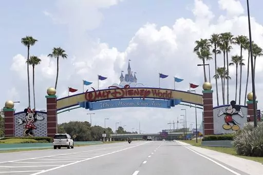 Cars drive under a sign greeting visitors near the entrance to Walt Disney World, July 2, 2020, in Lake Buena Vista, Fla. The first meeting of the new board of Walt Disney World’s government — overhauled by sweeping legislation signed by Republican Gov. Ron DeSantis as an apparent punishment for Disney publicly challenging Florida’s so-called “Don’t Say Gay” bill — dealt with the rote affairs any other municipal government handles. Board members on Wednesday, March 8, 2023, faced c