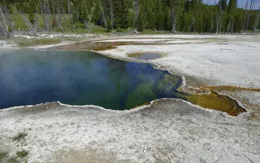 In this photo provided by the National Park Service is the Abyss Pool hot spring in the southern part of Yellowstone National Park, Wy., in June 2015. Park officials are investigating after part of a foot, in a shoe, was found floating in the hot spring on Tuesday, Aug. 16, 2022. (Diane Renkin/National Park Service via AP)