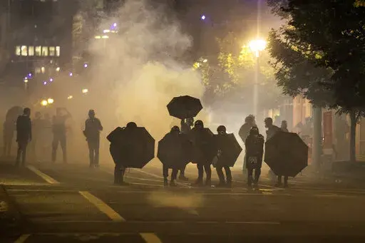 Tear gas fills the air during protests in Portland, Ore., on Sept. 18, 2020. Questions posed by lawmakers, medical workers and experts about the safety of tear gas remain unanswered, even after more than a dozen U.S. senators asked a congressional watchdog to look into the issue. (AP Photo/Paula Bronstein, File)