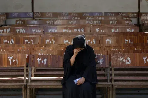 A 19-year old Hazara Afghan girl sits and cries on the bench she was sitting on, during Friday's suicide bomber attack on a Hazara education center, in Kabul, Afghanistan, Saturday, Oct. 1, 2022. Afghanistan's Hazaras, who are mostly Shiite Muslims, have been the target of a brutal campaign of violence for the past several years. (AP Photo/Ebrahim Noroozi)