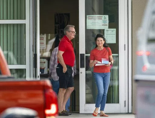 Voters exit the polls after casting their ballots on the first day of early voting at the Supervisor of Elections Main Office in West Palm Beach, Fla., on Oct. 24, 2022. Election officials in some Florida counties urged people to vote early Sunday, Nov. 6, where possible as a potential tropical system threatens the state on Election Day. The Palm Beach County elections supervisor, Wendy Sartory Link, said voters who want to avoid weather-related disruptions should cast their ballots by 7 p.m. Su