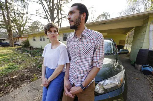Lauren Rhoades, 32, left, listens as her husband LaQuenza Morgan, 33, speaks on Feb. 24, 2022 about being checked at a roadblock a short distance from their home in north Jackson, Miss. The two are among several plaintiffs in a lawsuit claiming the Jackson police department is violating people's constitutional rights by using roadblocks to check for driver's licenses and car insurance in majority-Black and low-income neighborhoods. The lawsuit was settled on Wednesday, Oct. 5, 2022, and the city