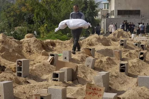 Palestinians bury the bodies of their relatives killed in the Israeli bombardment of the Gaza Strip, at a cemetery in Deir Al-Balah, Gaza, Monday, Oct. 23, 2023. Palestinians say the devastating war between Israel and Hamas is robbing them not only of their loved ones but also of the funeral rites that long have offered mourners some dignity and closure in the midst of grief. (AP Photo/Hatem Moussa, File)