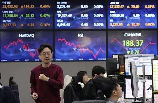 A currency trader passes by the screens showing the foreign exchange rates at the foreign exchange dealing room of the KEB Hana Bank headquarters in Seoul, South Korea, Tuesday, March 28, 2023. Asian shares were mostly higher on Tuesday as investors got some relief from worries over troubled U.S. banks with a planned takeover of failed Silicon Valley Bank.(AP Photo/Ahn Young-joon)