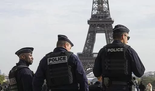 Police officers patrol the Trocadero plaza near the Eiffel Tower in Paris, Tuesday, Oct. 17, 2023. Police have arrested a man climbing on the Eiffel Tower. The drama temporarily stranded a crowd at the top. Among those trapped was a Washington, D.C., couple who decided during the wait to get married and an Associated Press reporter who got their story. Amir Khan had been planning to propose to Kate Warren later Thursday in a Paris garden away from the crowds, with a romantic dinner on the River 