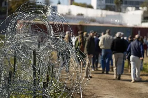 Concertina wire lines the path as members of Congress tour an area near the Texas-Mexico border, Jan. 3, 2024, in Eagle Pass, Texas. A divided Supreme Court on Monday, Jan. 22, allowed Border Patrol agents to cut razor wire that Texas installed on the U.S.-Mexico border, while a lawsuit over the wire continues. (AP Photo/Eric Gay, File)