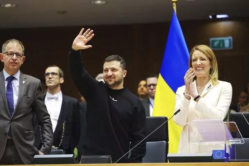 Ukraine's President Volodymyr Zelenskyy, centre, gestures as European Parliament's President Roberta Metsola, right, applauds during an EU summit at the European Parliament in Brussels, Belgium, Thursday, Feb. 9, 2023. On Thursday, Zelenskyy will join EU leaders at a summit in Brussels, which German Chancellor Olaf Scholz described as a "signal of European solidarity and community." (AP Photo/Olivier Matthys)