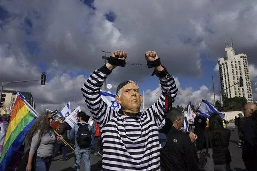 A protester wearing a rubber mask depicting Israeli Prime Minister Benjamin Netanyahu demonstrates in front of the Supreme Court in Jerusalem against the appointment of Aryeh Deri, the leader of the ultra-Orthodox Shas party as the country's new health minister, Thursday, Jan, 5, 2023. (AP Photo/Mahmoud Illean, File)