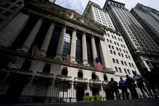 Pedestrians walk past the New York Stock Exchange, Friday, July 8, 2022, in New York. Stocks are swinging between small gains and losses as Wall Street works out what to make of surprisingly strong data on the U.S. jobs market released Friday. 
(AP Photo/John Minchillo)
