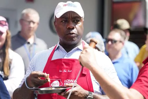 Republican presidential candidate Sen. Tim Scott, R-S.C., eats pork after working the grill at the Iowa Pork Producers tent at the Iowa State Fair, Tuesday, Aug. 15, 2023, in Des Moines, Iowa. (AP Photo/Charlie Neibergall)