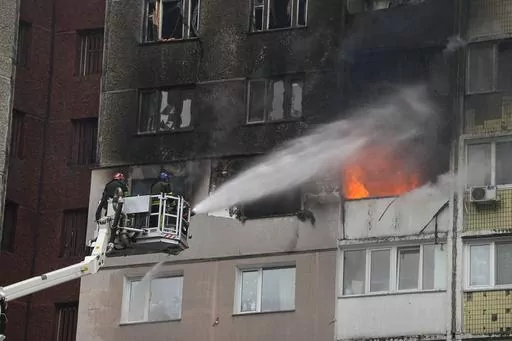 Firefighters work to extinguish a fire in an apartment building after Russian attack in Kyiv, Ukraine, Wednesday, Feb. 7, 2024. Authorities say Russia has fired cruise and ballistic missiles and Shahed-type drones at targets across Ukraine including the capital Kyiv. Officials said the Wednesday morning attack killed at least one civilian and injured 10 others. (AP Photo/Efrem Lukatsky)