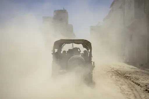 Israeli army vehicles transport a group of soldiers and journalists inside the southern Gaza Strip, Wednesday, July 3, 2024. The Israeli military invited reporters for a tour of Rafah, where the military has been operating since May 6. (AP Photo/Ohad Zwigenberg, Pool)