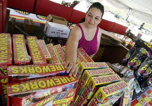 Dominique Tafoya arranges some of the new fireworks stock at a local fireworks concession stand, July 1, 2011, in Phoenix. Extremely hot, dry conditions forecast through the Fourth of July across much of the West are heightening concerns about wildfires and the dangers of fireworks. (AP Photo/Ross D. Franklin, File)