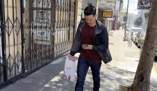 Andy Fang, DoorDash’s co-founder and chief technology officer, picks up and delivers food orders to customers in downtown San Francisco on Saturday, June 15, 2023. Fang is one of a growing number of executives who work shifts on the front lines of the companies they run. All DoorDash salaried employees are required to make deliveries or work directly with customers or merchants several times a year. (AP Photo/Terry Chea)