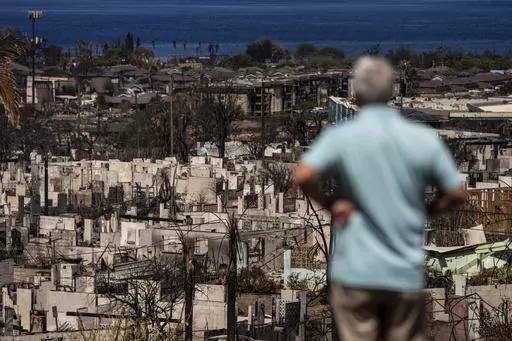 A man views the aftermath of a wildfire in Lahaina, Hawaii, Saturday, Aug. 19, 2023. Nearly a month after the deadliest U.S. wildfire in more than a century killed scores of people, authorities on Maui are working their way through a list of the missing that has grown almost as quickly as names have been removed. Lawsuits are piling up in court over liability for the inferno, and businesses across the island are fretting about what the loss of tourism will mean for their futures. (AP Photo/Jae C