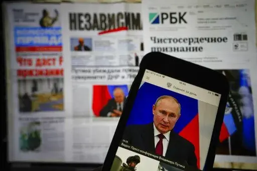 The app of the Russian government newspaper is displayed on an iPhone screen showing Russian President Vladimir Putin during his speech in the Kremlin in Moscow, Russia, Tuesday, Feb. 22, 2022. As the West sounds the alarm about the Kremlin ordering troops into eastern Ukraine and decries an invasion, Russian state media paints a completely different picture. It portrays the move as Moscow coming to the rescue of war-torn areas tormented by Ukraine’s aggression and bringing them much-needed pe