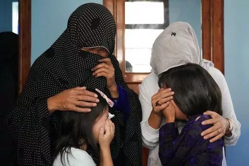 The family of a 19-years old girl who was victim of a suicide bomber mourns, in Kabul, Afghanistan, Friday, Sept. 30, 2022. A Taliban spokesman says a suicide bomber has killed several people and wounded others at an education center in a Shiite area of the Afghan capital. The bomber hit while hundreds of teenage students inside were taking practice entrance exams for university, a witness says. (AP Photo/Ebrahim Noroozi)