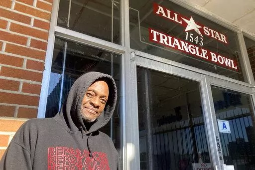 Orangeburg resident John Graves poses outside the All-Star Bowling Lanes in Orangeburg, S.C., on Sunday, Jan. 30, 2022. Graves and other visitors toured the empty bowling alley ahead of the 54th anniversary of the Orangeburg Massacre, when state troopers shot into a crowd of students protesting to integrate the business, killing three and wounding 28. (AP Photo/Michelle Liu)