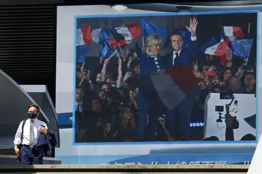 A public TV screen shows a news on French President Emanuel Macron winning a second term Monday, April 25, 2022, in Tokyo. Japan welcomed the reelection of Macron as key to the unity of Group of Seven at a time its members need to work together to end Russia's invasion of Ukraine as soon as possible. (AP Photo/Eugene Hoshiko)