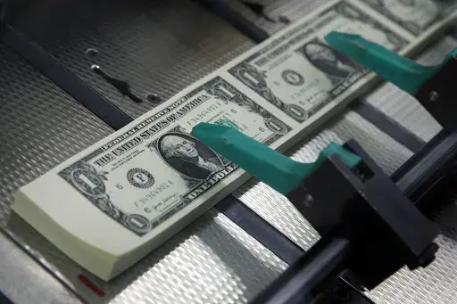 FILE- In this Nov. 15, 2017, file photo, new $1 bills are cut and stacked at the Bureau of Engraving and Printing in Washington. It pays to know the difference between a good 401(k) and a great 401(k). Compared to an average plan, great plans offer features that could potentially lead to tens of thousands of dollars in additional retirement money. Learn the ins and outs of your current 401(k) and compare it to some of the hallmarks of a great 401(k).  (AP Photo/Jacquelyn Martin, File)
