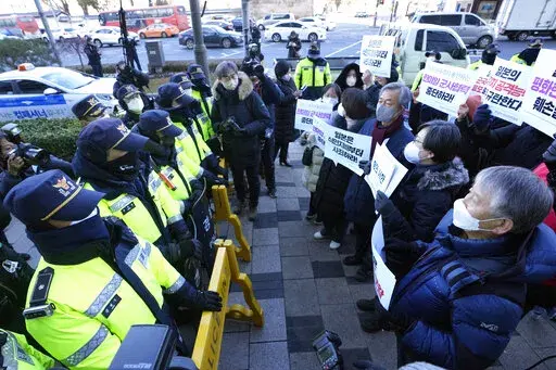 Protesters confront police officers during a rally to oppose Japan's adoption of a new national security strategy near the Japanese Embassy in Seoul, South Korea, Tuesday, Dec. 20, 2022. North Korea threatened Tuesday to take "bold and decisive military steps" against Japan as it slammed Tokyo's adoption of a national security strategy as an attempt to turn the country into an aggressive military power. The banners read "Stop military cooperation between South Korea, the U.S. and Japan military 