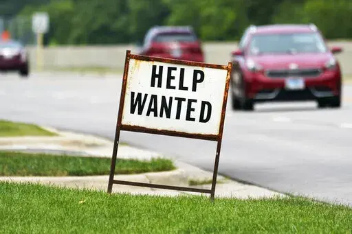 A help wanted sign is displayed at a gas station in Mount Prospect, Ill., Tuesday, July 27, 2021.  Fewer Americans applied for unemployment benefits last week as layoffs remain at historically low levels.  Jobless claims fell by 5,000 to 166,000 for the week ending April 2, 2022 the Labor Department reported Thursday.  (AP Photo/Nam Y. Huh)