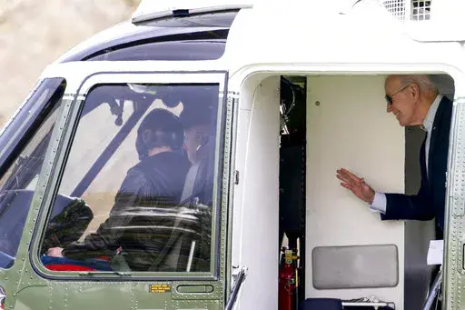 President Joe Biden waves to the pilots on Marine One as he arrives at the White House in Washington, Sunday, March 20, 2022, after spending the weekend in Rehoboth Beach, Del. (AP Photo/Andrew Harnik)