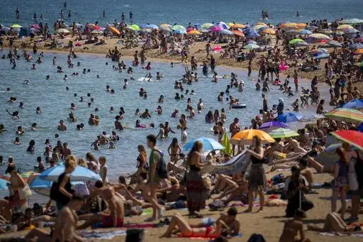 People cool off in the water on a hot and sunny day at the beach in Barcelona, Spain, July 15, 2022. Earth’s fever persisted last year, not quite spiking to a record high but still in the top five or six warmest on record, government agencies reported Thursday, Jan. 12, 2023. (AP Photo/Emilio Morenatti, File)