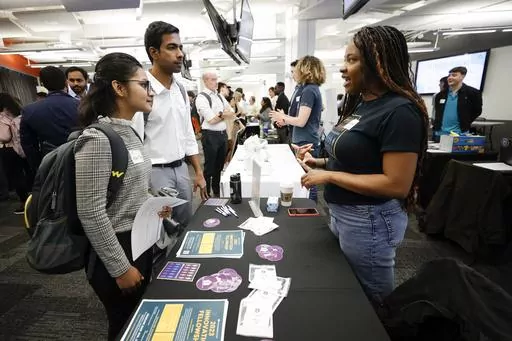 Georgia State University students Kavita Javalagi, left, and Gana Natarajan, second from left, speak with Shetundra Pinkston, during the Startup Student Connection job fair, Wednesday, March 29, 2023, in Atlanta. For the thousands of workers who'd never experienced upheaval in the tech sector, the recent mass layoffs at companies like Google, Microsoft, Amazon and Meta came as a shock. Now they are being courted by long-established employers whose names aren't typically synonymous with tech work