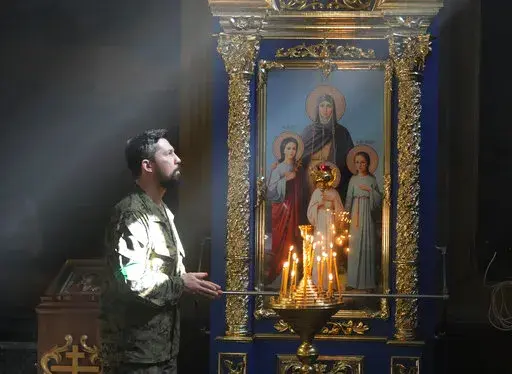 A Ukrainian soldier prays in St. Michael Cathedral during Easter celebration in Kyiv, Ukraine, Sunday, April 24, 2022. (AP Photo/Efrem Lukatsky)