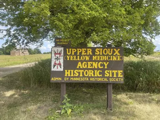 A large wooden sign that says "Upper Sioux (Yellow Medicine) Agency Historic Site" stands at the Upper Sioux Agency State Park near Granite Falls, Minn., on July 28, 2023. The golden prairies and winding rivers of the state park also hold the secret burial sites for Dakota people who died as the U.S. failed to fulfill treaties with Native Americans over a century ago — and now their descendants are getting that land back. (AP Photo/Trisha Ahmed)
