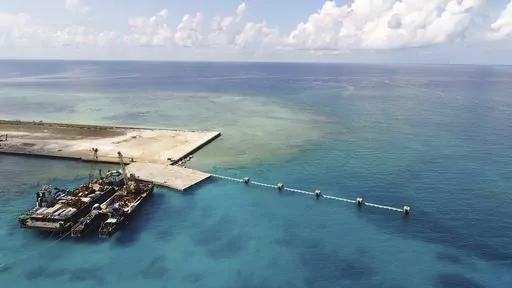 In this photo provided by the Department of National Defense PAS, ships carrying construction materials are docked at the newly built beach ramp at the Philippine-claimed island of Pag-asa, also known as Thitu, in the disputed South China Sea on June 9, 2020. The Philippine coast guard inaugurated a new monitoring base Friday, Dec. 1, 2023, on a remote island occupied by Filipino forces in the disputed South China Sea as Manila ramps up efforts to counter China’s increasingly aggressive action