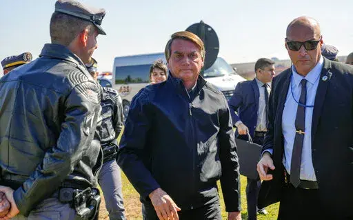 Brazilian President Jair Bolsonaro arrives to a resort hotel where he is expected to meet with Elon Musk in Porto Feliz, Brazil, Friday, May 20, 2022. The Telsa and SpaceX chief executive officer tweeted that he was in Brazil to help bring Internet service to rural schools in the Amazon and to help monitor the Amazon environmentally. (AP Photo/Andre Penner)